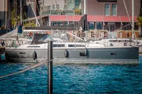 2023 Hanse 388 yacht docked in a marina, surrounded by calm blue water.