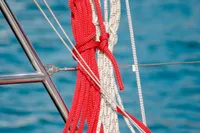 Red and white ropes on a 2023 Hanse 388 sailboat against blue water.