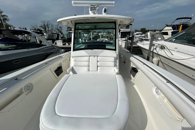  Yacht Photos Pics 2016 Boston Whaler 370 Outrage boat with white seating, docked among other boats.