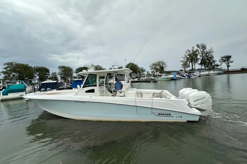 Yacht Photos Pics 2016 Boston Whaler 370 Outrage boat on water near marina, overcast sky.