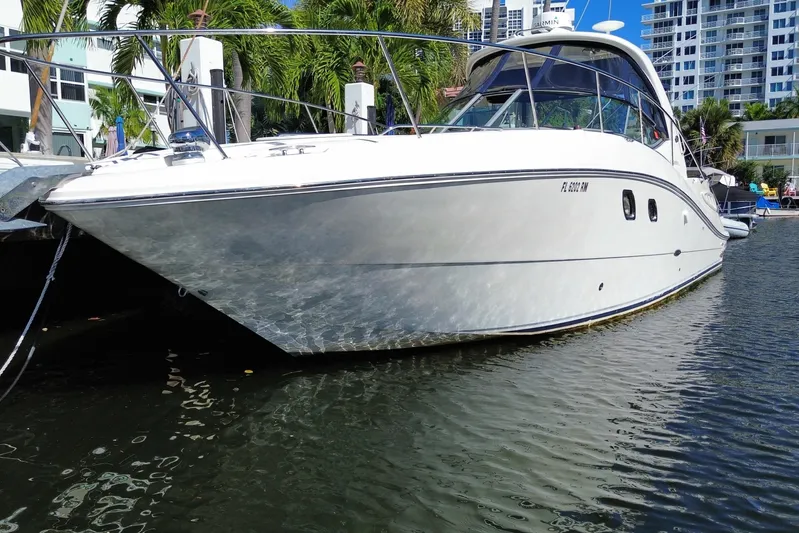  Yacht Photos Pics 2008 Sea Ray Sundancer 330 yacht docked in a marina, surrounded by palm trees and buildings.