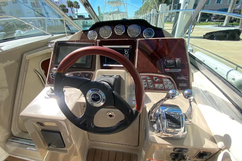  Yacht Photos Pics 2008 Sea Ray Sundancer 330 helm with steering wheel, gauges, and controls in a marina setting.