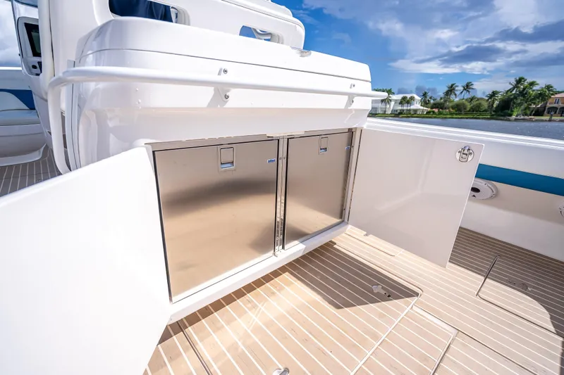  Yacht Photos Pics 2018 Intrepid 407 boat with open storage compartment, sleek design, and scenic waterfront view.
