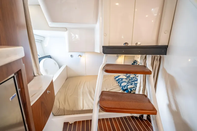  Yacht Photos Pics Interior cabin of 2018 Intrepid 407 boat with wooden steps and cozy sleeping area.