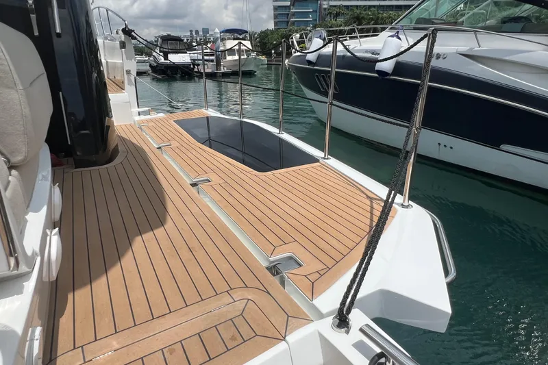  Yacht Photos Pics 2024 Galeon 440 Fly yacht deck with sleek wooden finish, docked at marina.