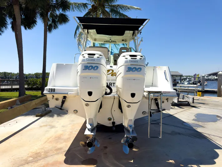 Pearl Yacht Photos Pics 2018 Boston Whaler 315 Conquest with twin 300 horsepower engines, docked under palm trees.