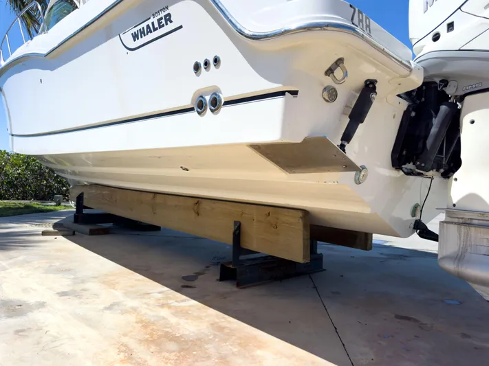 Pearl Yacht Photos Pics 2018 Boston Whaler 315 Conquest boat on wooden supports, viewed from the stern.