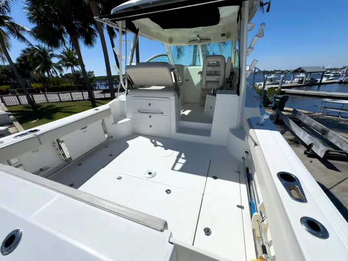 Pearl Yacht Photos Pics 2018 Boston Whaler 315 Conquest boat deck with seating, docked near marina.
