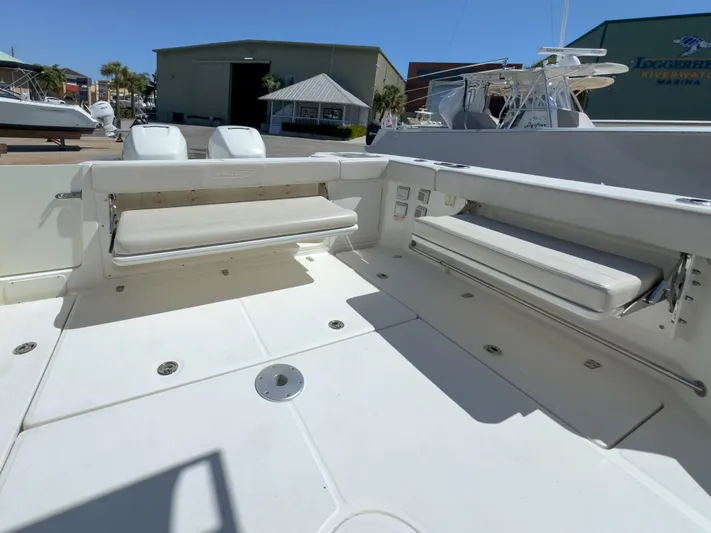 Pearl Yacht Photos Pics 2018 Boston Whaler 315 Conquest boat deck with foldable seating in marina setting.