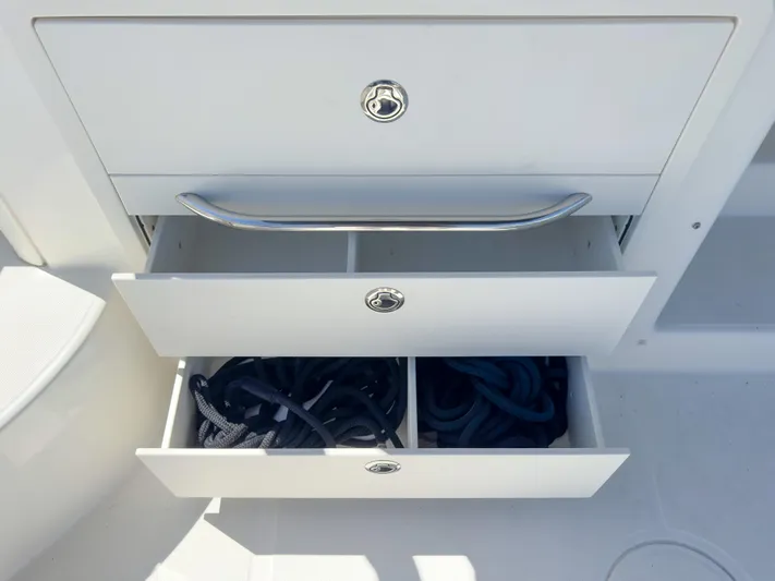 Pearl Yacht Photos Pics Open storage drawers on a 2018 Boston Whaler 315 Conquest boat, containing ropes.