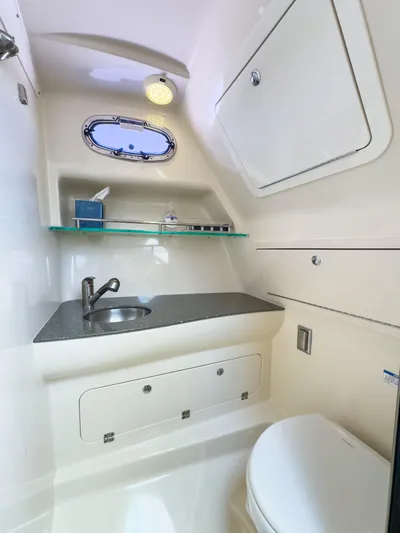 Pearl Yacht Photos Pics 2018 Boston Whaler 315 Conquest bathroom with sink, toilet, and storage cabinets.