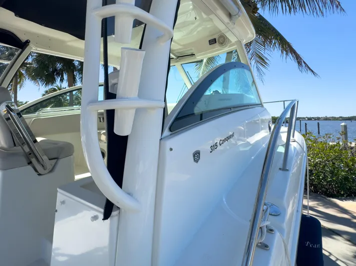 Pearl Yacht Photos Pics 2018 Boston Whaler 315 Conquest boat docked near palm trees and water.