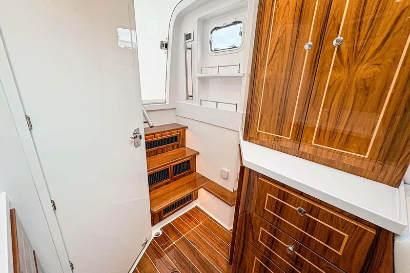  Yacht Photos Pics Manufacturer Provided Image: Luxurious interior of 2026 HCB 48 Campeon yacht with wooden cabinetry and stairs.