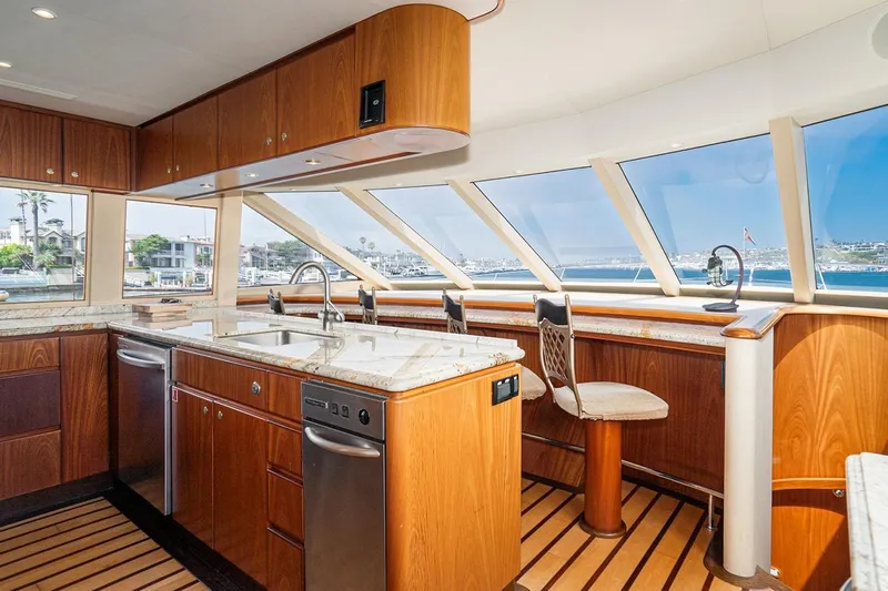 Fan Tail Yacht Photos Pics Luxurious kitchen interior of 2003 West Bay Sonship yacht with panoramic windows and wooden cabinetry.