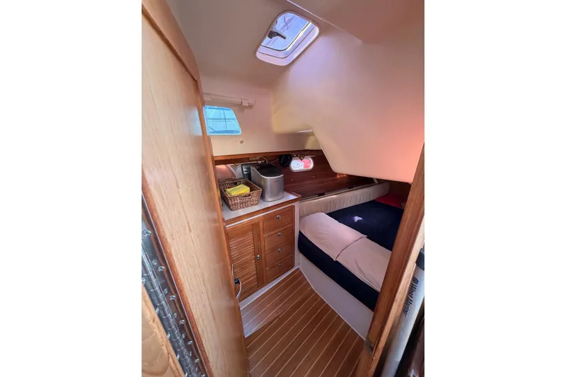 Seaduction Yacht Photos Pics Cozy cabin interior of 2005 Catalina 42 MkII sailboat with wooden cabinetry and bedding.