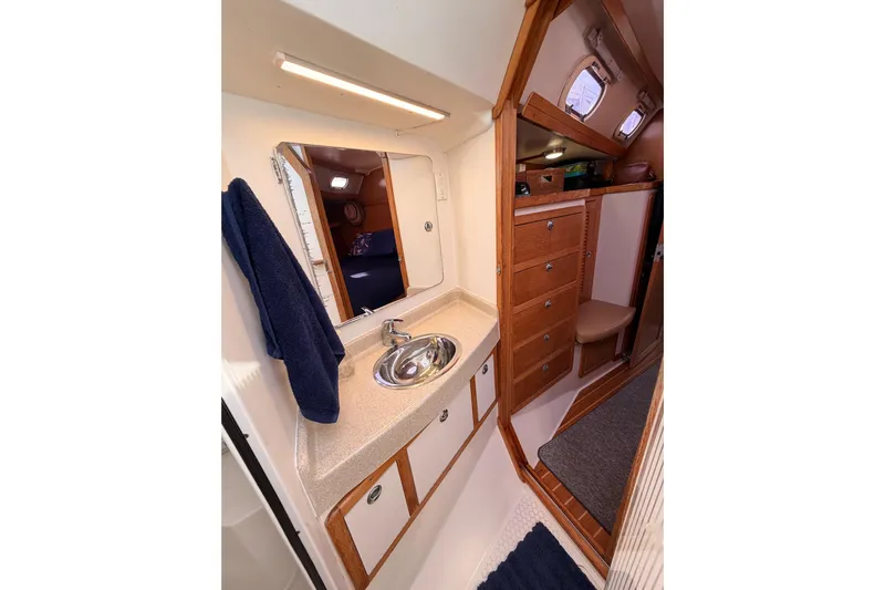 Seaduction Yacht Photos Pics 2005 Catalina 42 MkII yacht interior with sink, mirror, and wooden cabinetry.