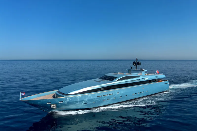 Queen Blue Yacht Photos Pics Luxurious 2007 Baglietto 44 Fast yacht cruising on open sea under clear blue sky.