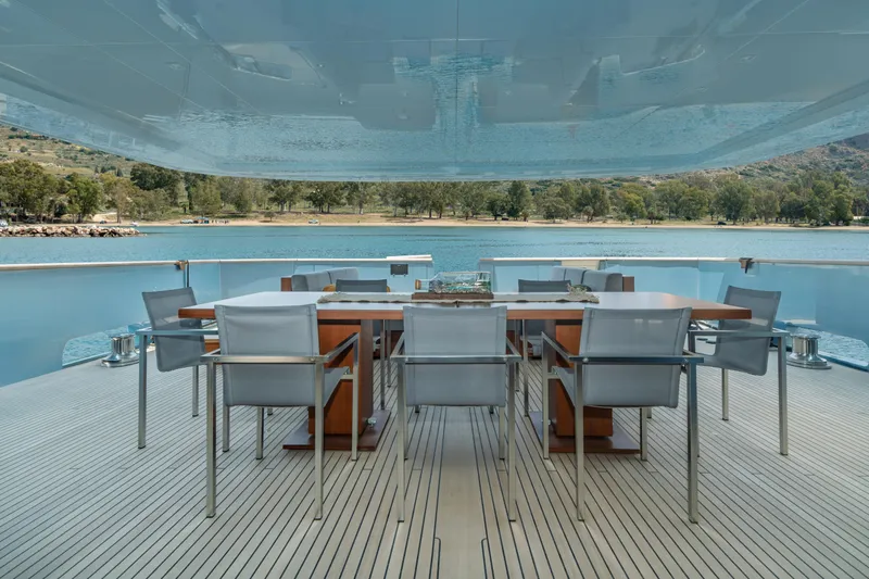 Queen Blue Yacht Photos Pics Luxury dining area on 2007 Baglietto 44 Fast yacht, overlooking serene waters and lush shoreline.