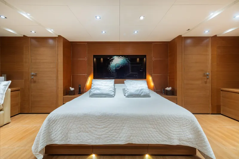 Queen Blue Yacht Photos Pics Luxurious bedroom interior on 2007 Baglietto 44 Fast yacht, featuring modern wood paneling and elegant bedding.