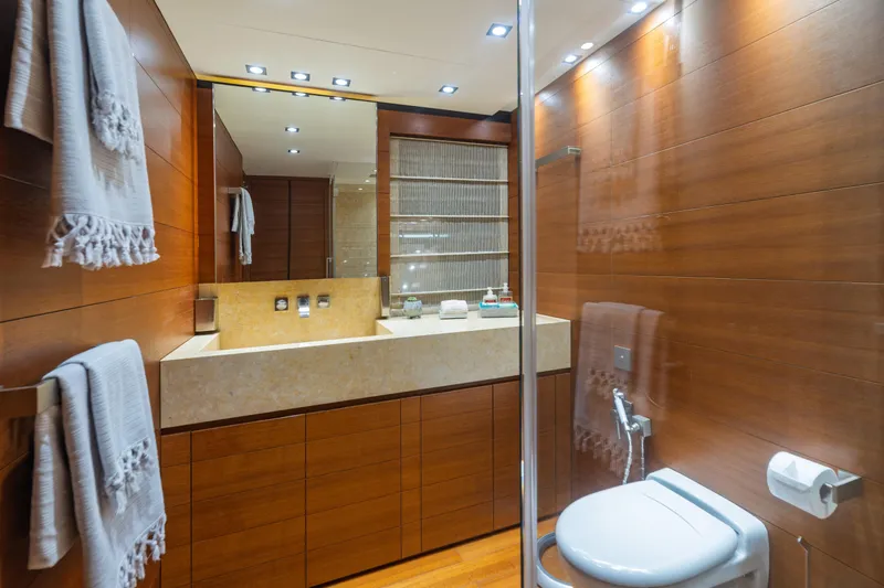 Queen Blue Yacht Photos Pics Luxurious bathroom on 2007 Baglietto 44 Fast yacht, featuring wood paneling and modern fixtures.