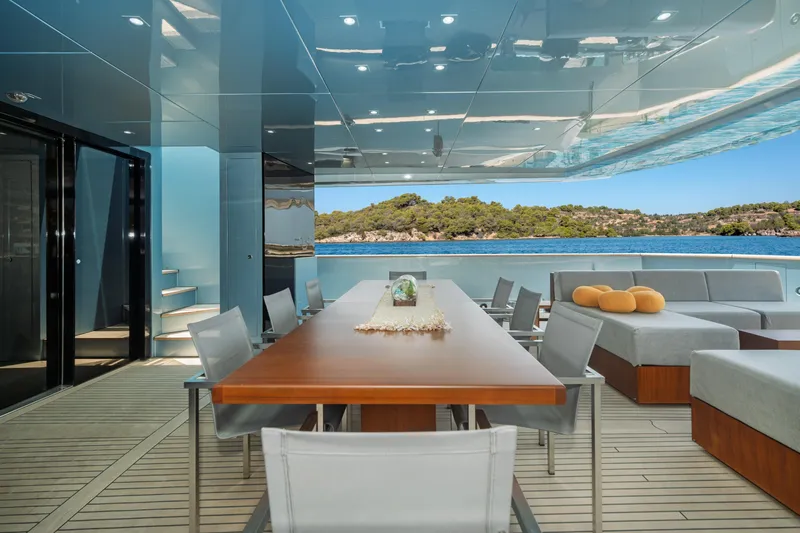 Queen Blue Yacht Photos Pics Luxurious 2007 Baglietto 44 Fast yacht deck with elegant dining area and scenic ocean view.