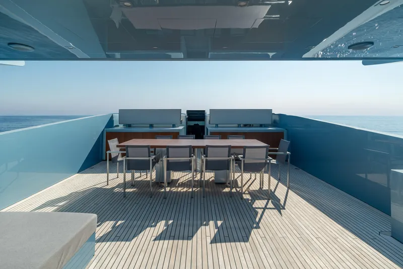 Queen Blue Yacht Photos Pics Luxurious 2007 Baglietto 44 Fast yacht deck with modern dining area and ocean view.