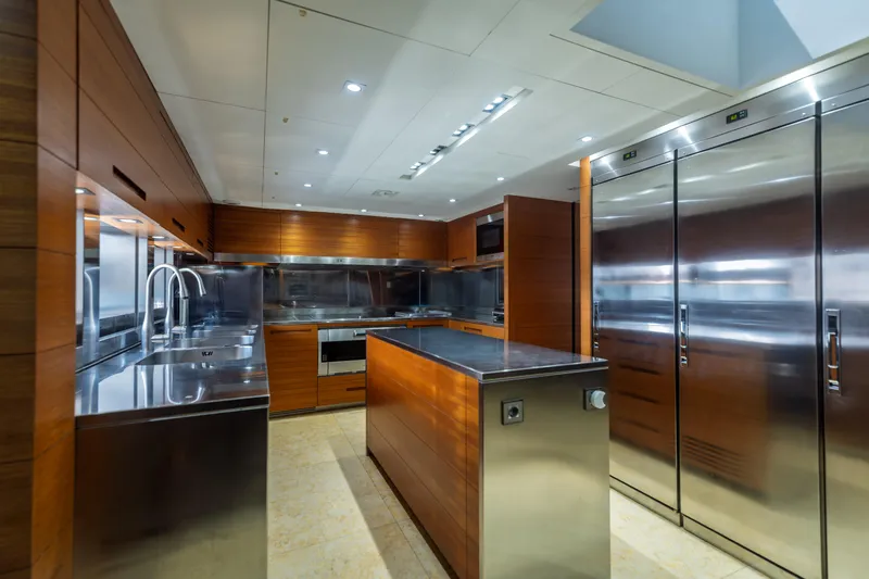 Queen Blue Yacht Photos Pics Luxurious kitchen interior on 2007 Baglietto 44 Fast yacht, featuring stainless steel and wood finishes.