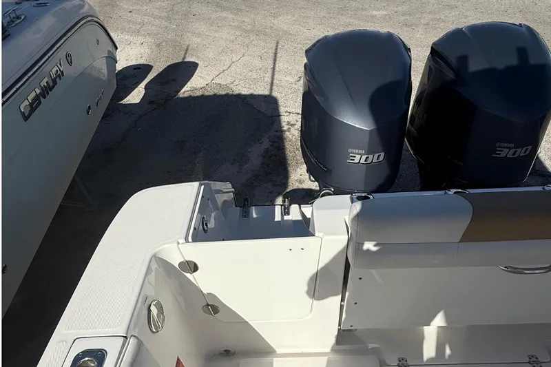  Yacht Photos Pics Edgewater 280CC 2016 boat with twin Yamaha 300 engines, docked beside another vessel.