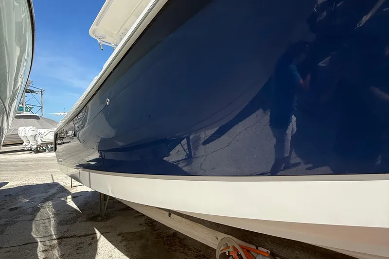  Yacht Photos Pics 2016 Edgewater 280CC boat with sleek blue hull, docked outdoors.