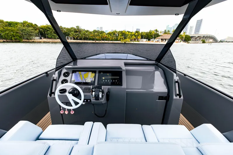  Yacht Photos Pics 2022 Vanquish Yachts VQ40 helm station with modern navigation system on a serene waterway.