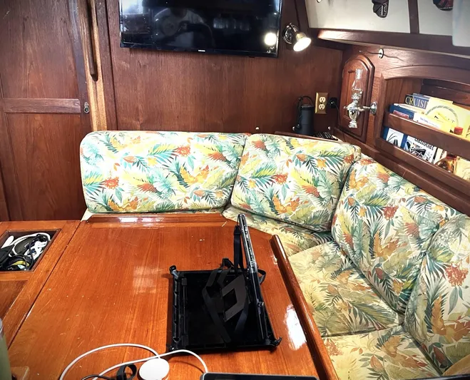 Remedy Yacht Photos Pics Cozy interior of 1995 Pacific Seacraft 37 sailboat with floral upholstery and wooden accents.