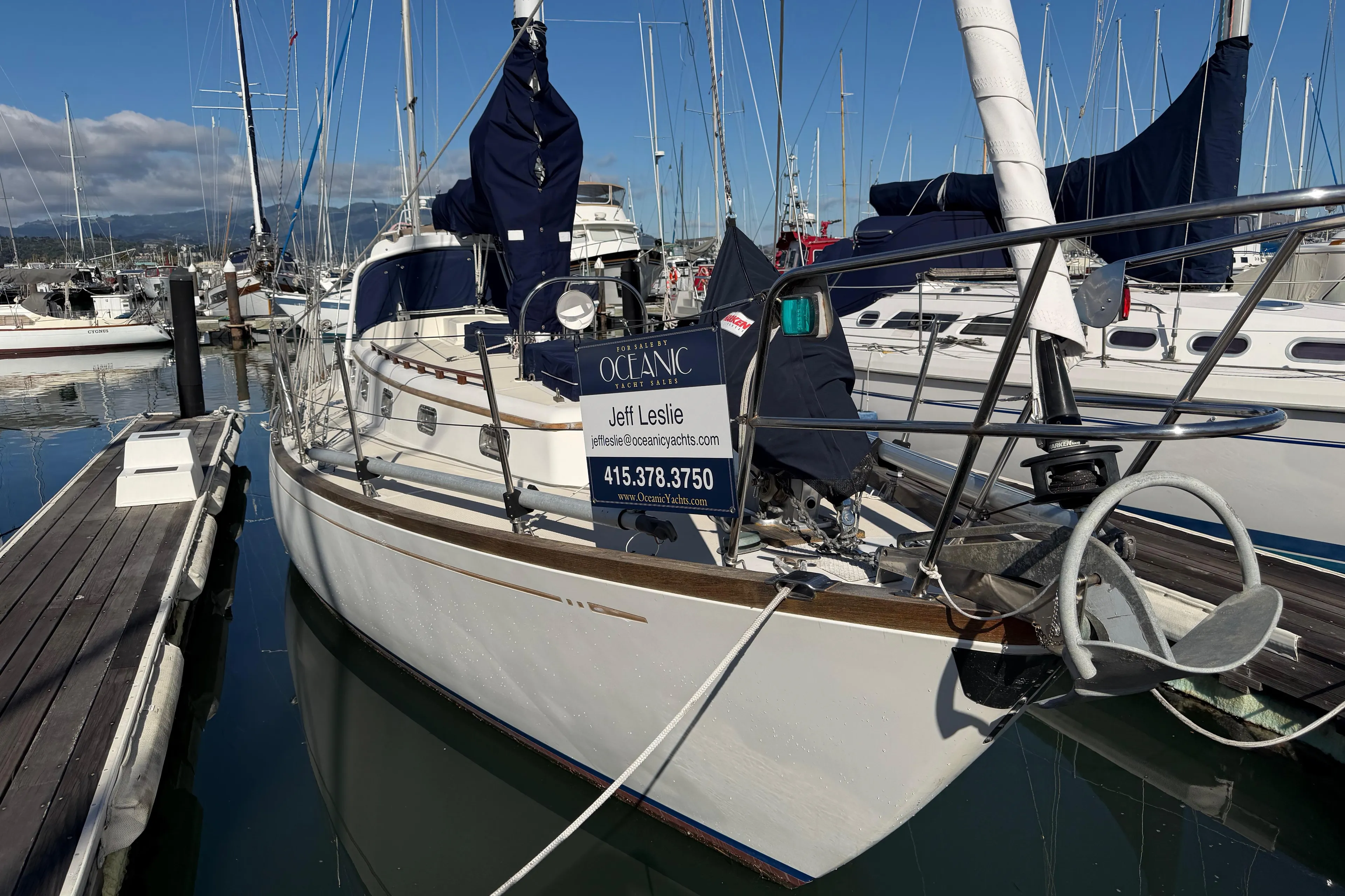 Sailboat docked at marina, Mason 33 model, 1985, with contact information displayed.
