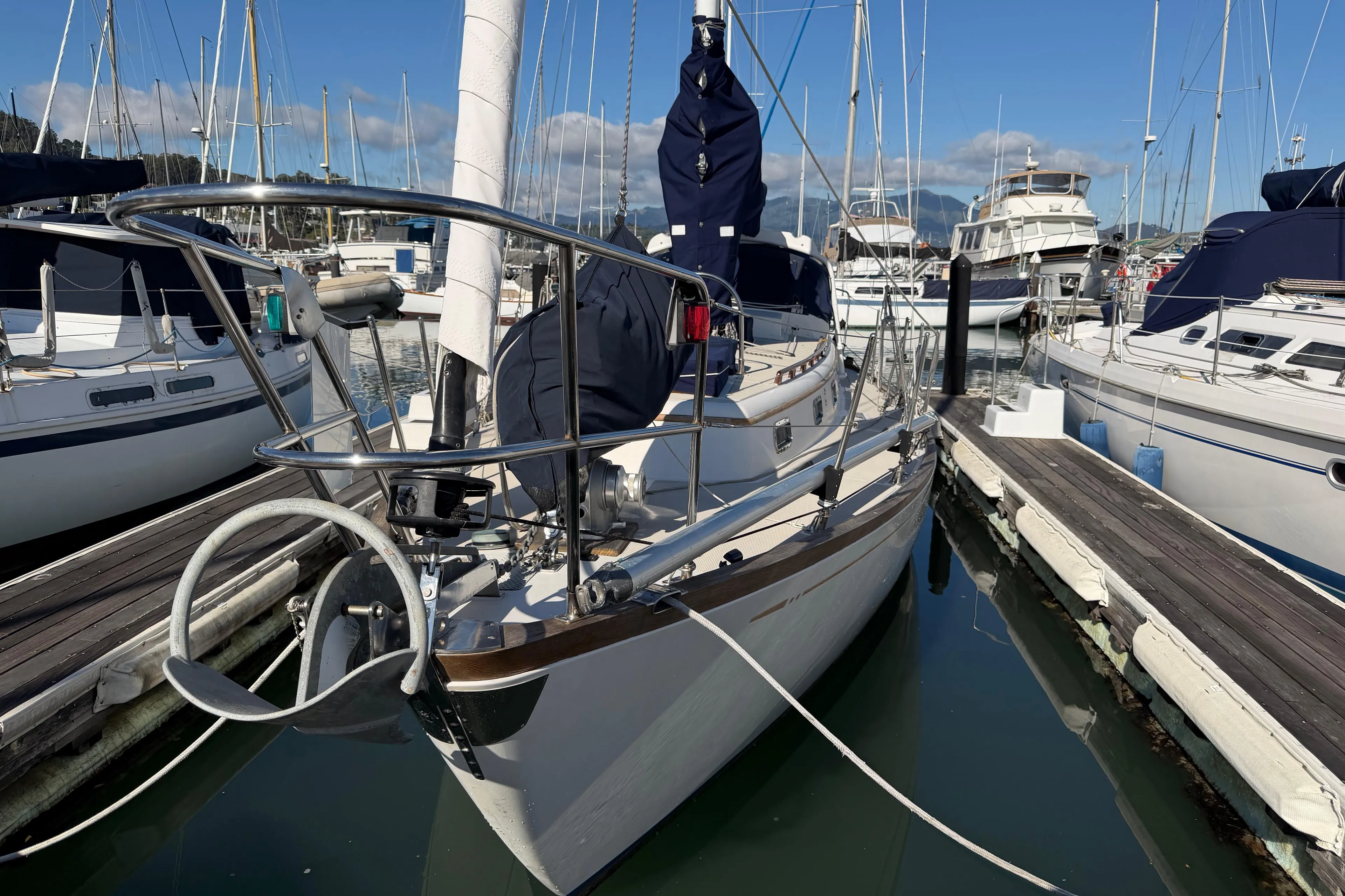 Sailboat docked in marina, Mason 33 model, 1985, surrounded by other boats.