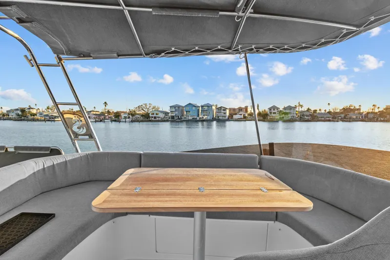 Unfiltered Yacht Photos Pics Beneteau Swift Trawler 35, 2023 model, featuring a cozy outdoor seating area with waterfront view.