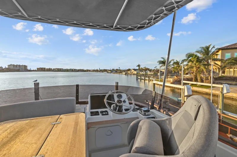 Unfiltered Yacht Photos Pics Beneteau Swift Trawler 35, 2023 model, helm view with waterfront scenery.