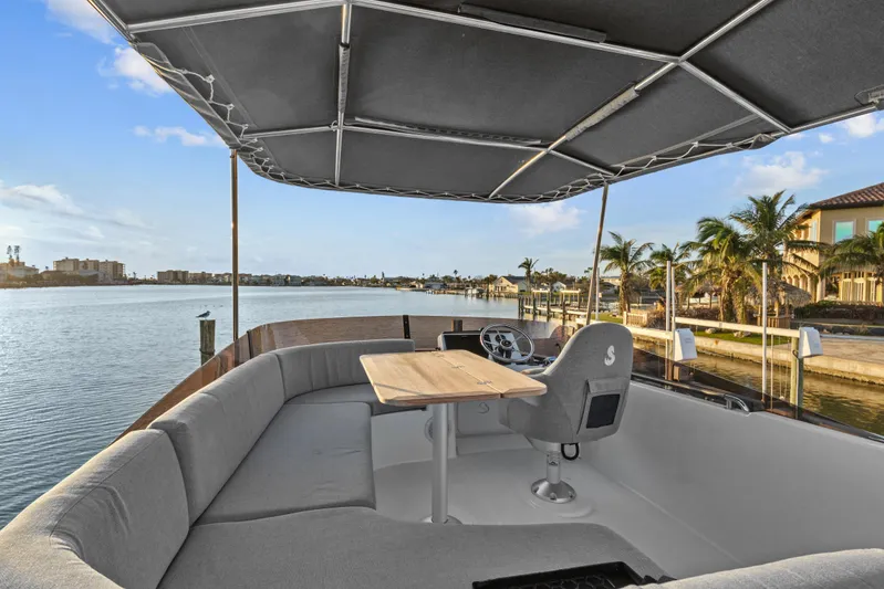 Unfiltered Yacht Photos Pics 2023 Beneteau Swift Trawler 35, spacious deck with seating, table, and waterfront view.