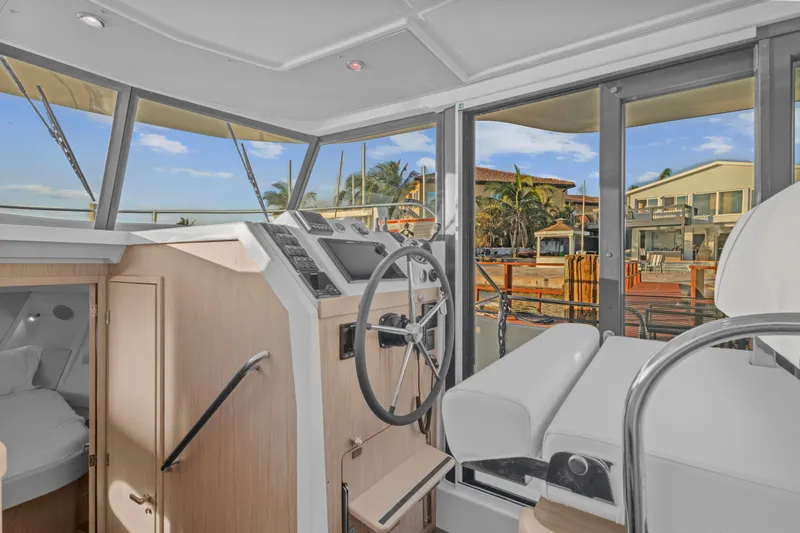 Unfiltered Yacht Photos Pics 2023 Beneteau Swift Trawler 35 interior helm with modern controls and panoramic windows.