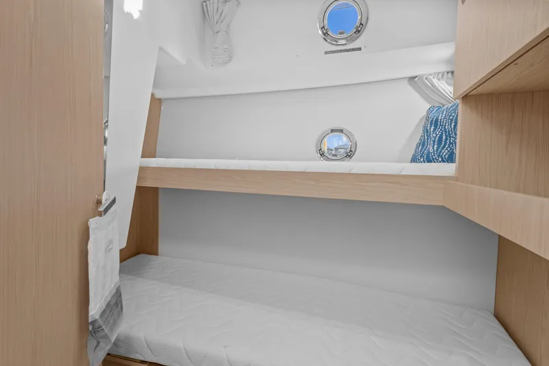 Unfiltered Yacht Photos Pics 2023 Beneteau Swift Trawler 35 cabin with bunk beds and portholes.