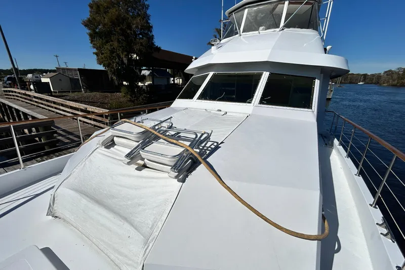 Nother Venture Yacht Photos Pics 1989 Hatteras 78 CPMY yacht docked by a serene waterfront.