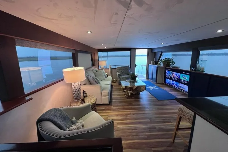 Nother Venture Yacht Photos Pics Luxurious interior of 1989 Hatteras 78 CPMY yacht with elegant seating and panoramic windows.