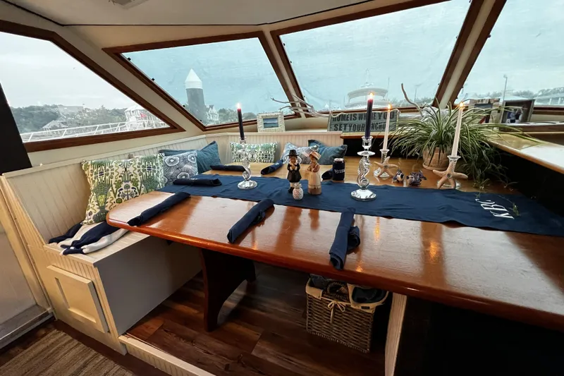 Nother Venture Yacht Photos Pics Cozy dining area on 1989 Hatteras 78 CPMY yacht with nautical decor and panoramic windows.