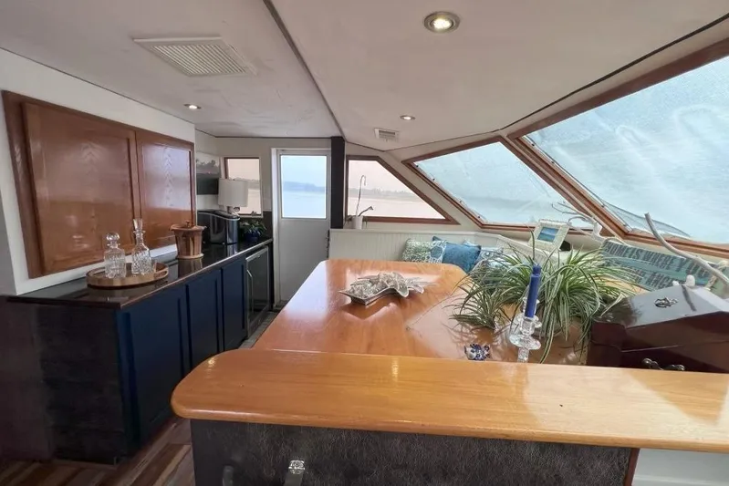 Nother Venture Yacht Photos Pics Interior of 1989 Hatteras 78 CPMY yacht with elegant wood finishes and large windows.