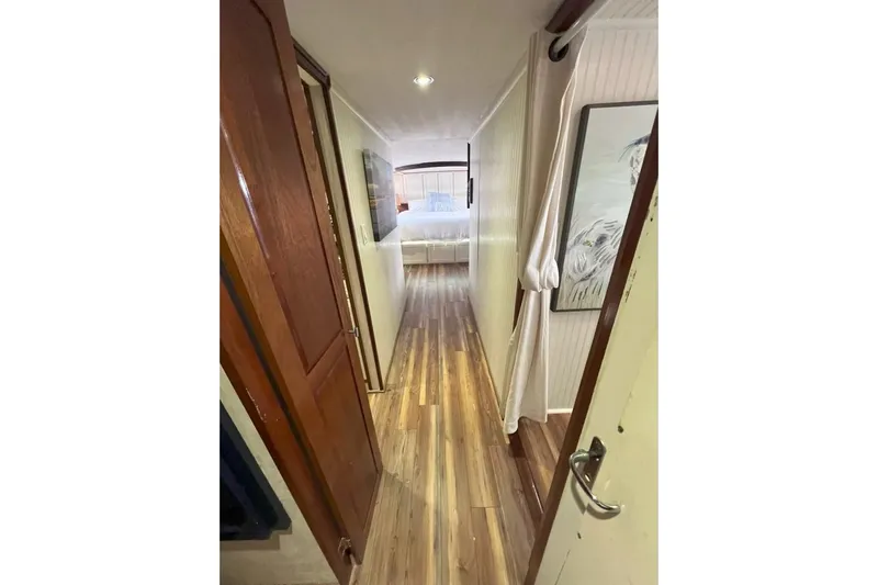 Nother Venture Yacht Photos Pics Hallway view inside 1989 Hatteras 78 CPMY yacht, featuring wooden flooring and elegant decor.