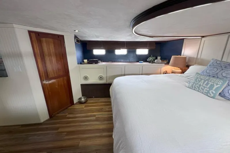 Nother Venture Yacht Photos Pics Bedroom interior of 1989 Hatteras 78 CPMY yacht with wooden flooring and cozy decor.