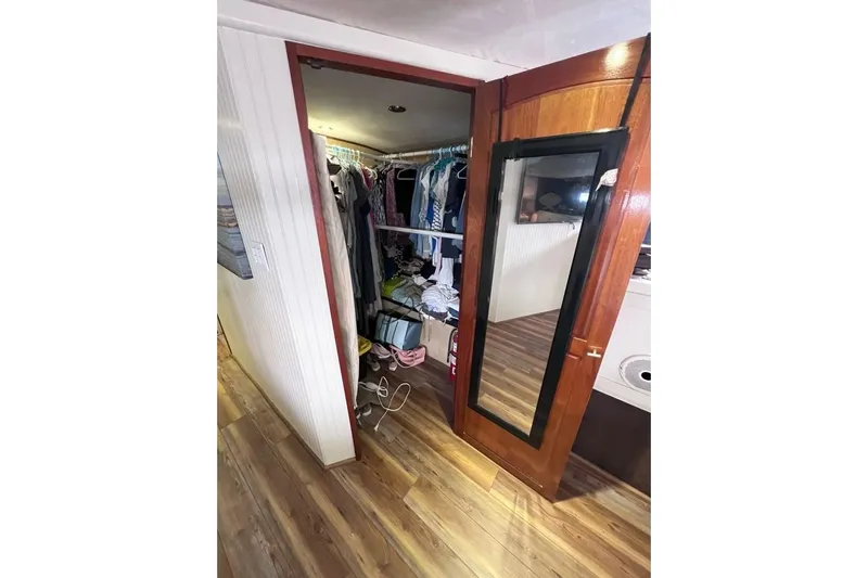 Nother Venture Yacht Photos Pics Closet interior on 1989 Hatteras 78 CPMY yacht with wooden flooring and mirrored door.