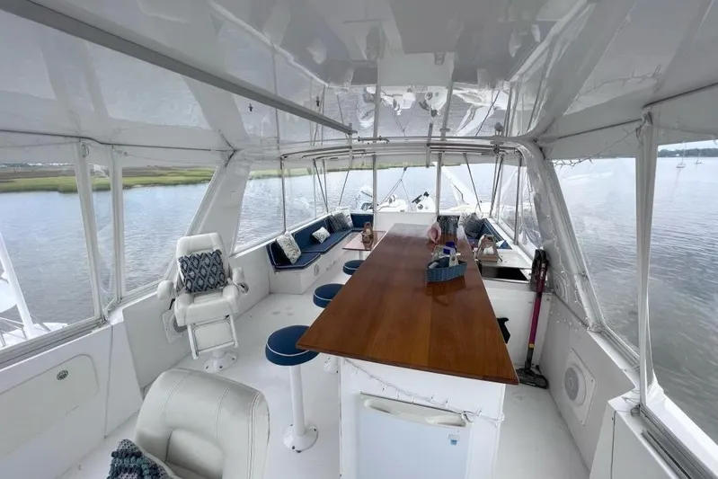 Nother Venture Yacht Photos Pics 1989 Hatteras 78 CPMY yacht interior with spacious seating and wooden table.