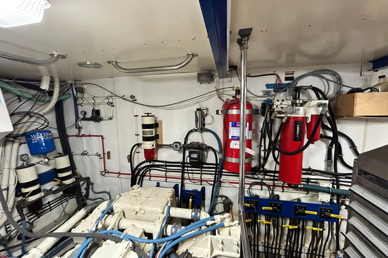 Nother Venture Yacht Photos Pics Engine room of 1989 Hatteras 78 CPMY yacht, featuring machinery and fire safety equipment.