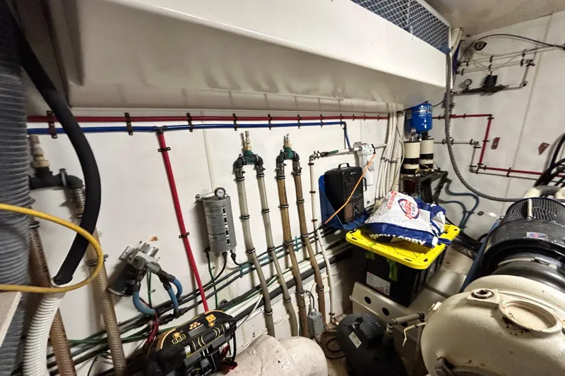 Nother Venture Yacht Photos Pics Engine room of 1989 Hatteras 78 CPMY yacht with pipes, cables, and equipment.