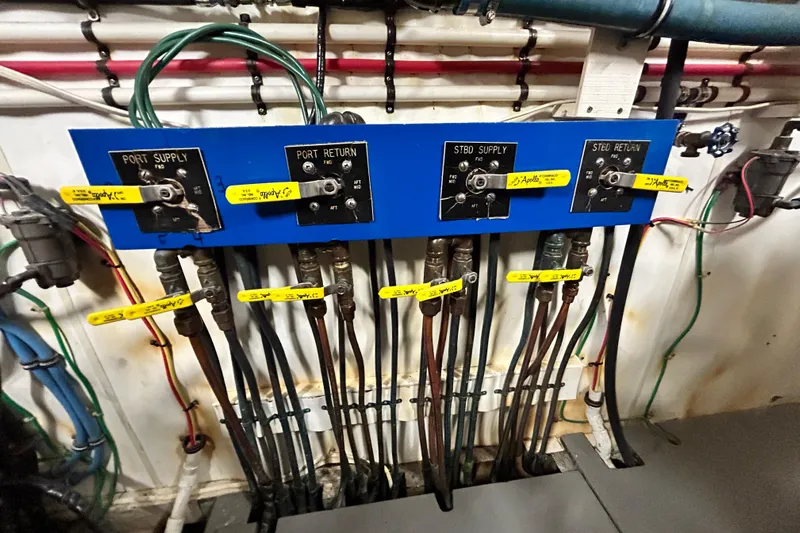 Nother Venture Yacht Photos Pics Engine room control panel of 1989 Hatteras 78 CPMY yacht with labeled valves and pipes.