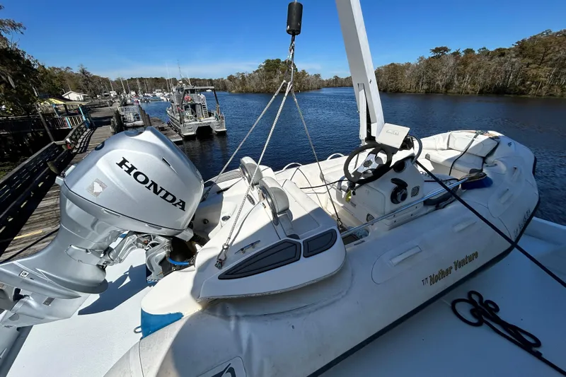 Nother Venture Yacht Photos Pics Inflatable boat with Honda motor on 1989 Hatteras 78 CPMY yacht, docked by a scenic river.